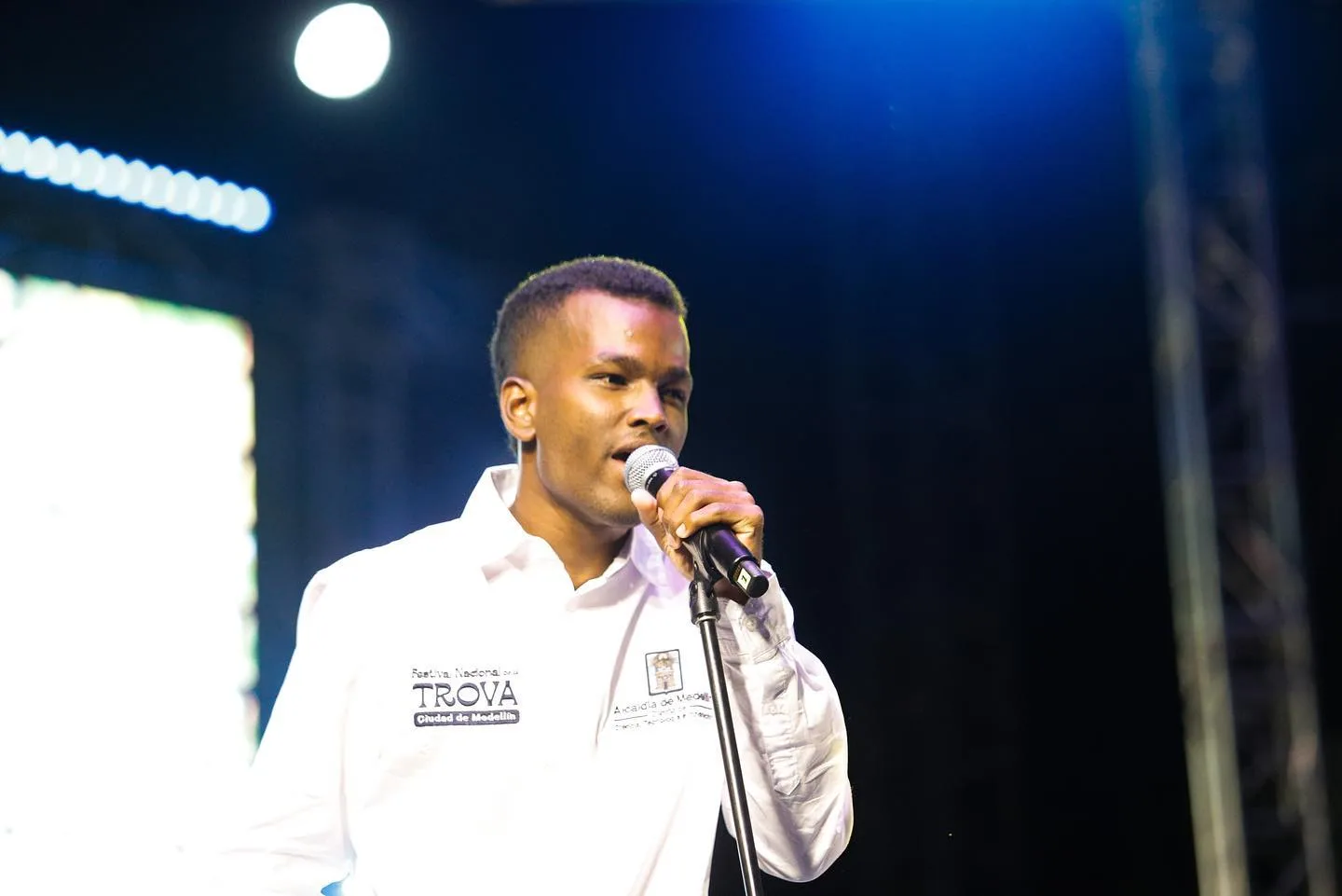 Joven trovador canta bajo luz azul
